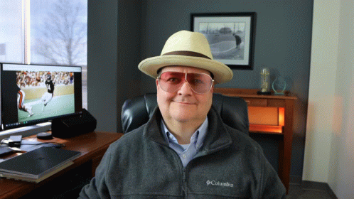 Man in Hat and Columbia Jacket Sitting at Computer