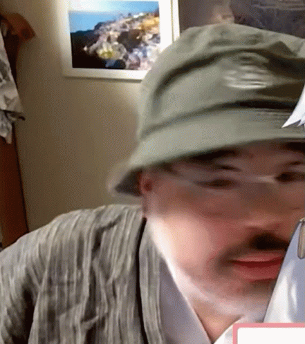 Man in Hat and Glasses Looking at Paper