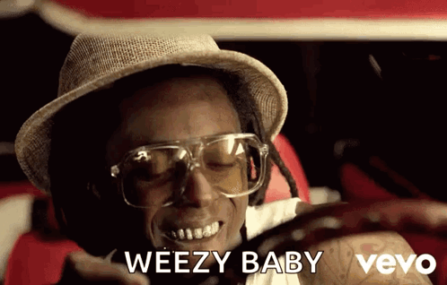 Man in Hat and Glasses Smiling Saying Weezy Baby