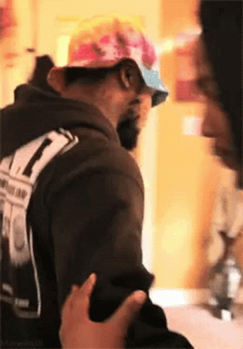 Man in Hat and Hoodie Being Touched