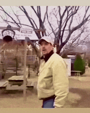 Man in Hat and Jacket Standing in Park