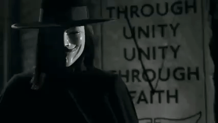 Man in Hat and Mask Standing in Front of Through Unity Through Faith Sign