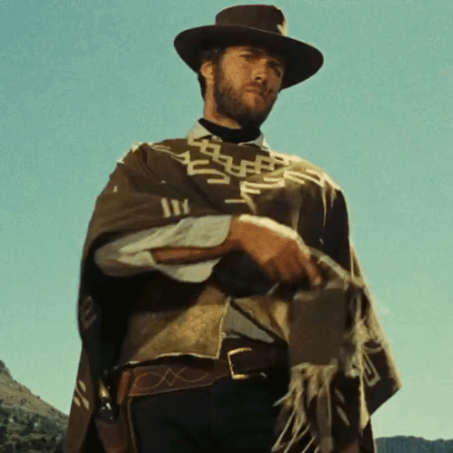 Man in Hat and Poncho Holding Gun