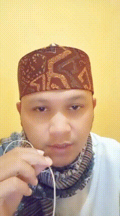 Man In Hat And Scarf Holding Earbuds GIF