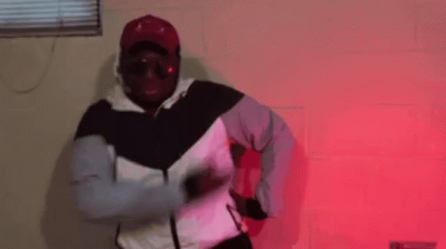 Man in Hat and Sunglasses Dancing in Red Room