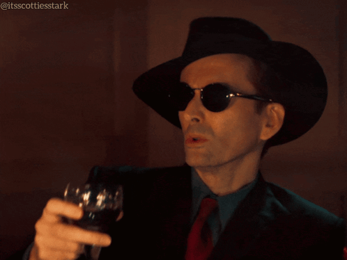 Man in Hat and Sunglasses Holding Wine Glass Saying Shades of Dark Gray