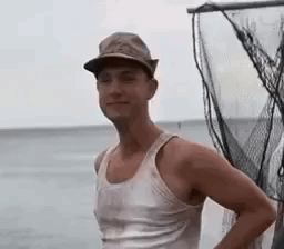 Man In Hat And Tank Top Standing By Fishing Net GIF