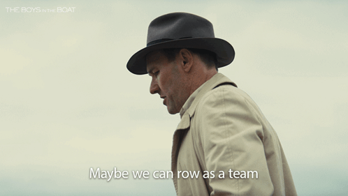 Man In Hat And Trench Coat Says Maybe We Can Row As A Team GIF