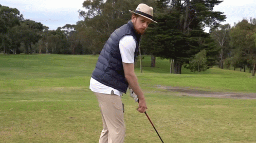 Man in Hat and Vest Holding Golf Club