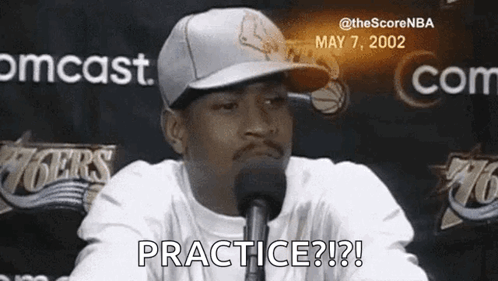Man in Hat at Microphone Saying Practice?