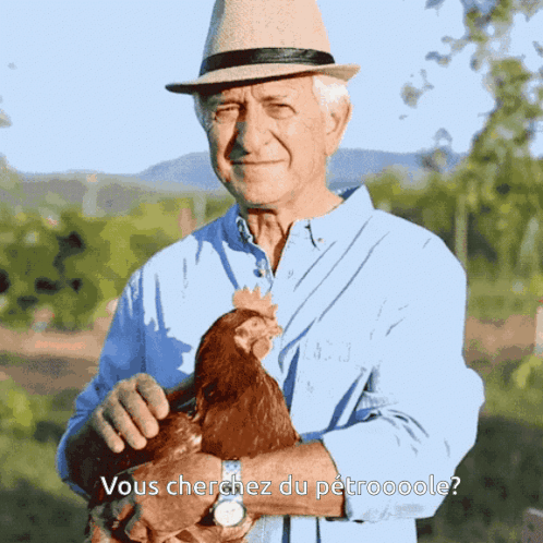 Man in Hat Holding Chicken Vous Cherchez Du Petroooole