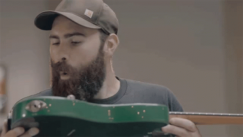 Man in Hat Holding Green Guitar