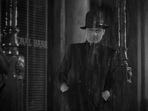 Man in Hat in Rain at National Bank