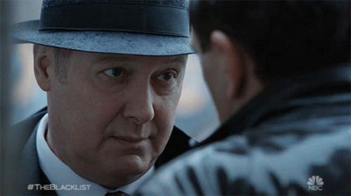Man In Hat Looking At Man In Suit And Tie Blacklist GIF