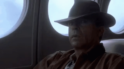 Man In Hat Looking Out Airplane Window GIF