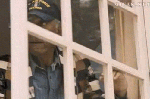 Man In Hat Looking Out Window GIF