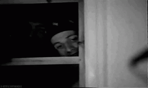 Man In Hat Peeking Out Window GIF