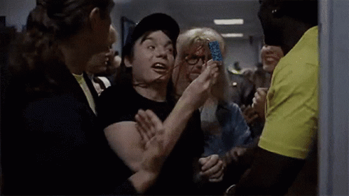 Man in Hat Saying Wayne's World Surrounded by People