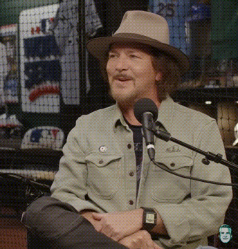 Man in Hat Sitting at Microphone