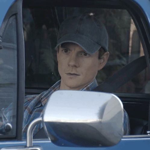 Man in Hat Sitting in Blue Car