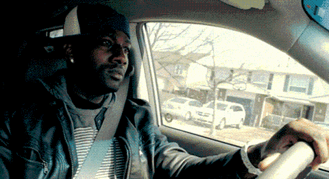 Man in Hat Sitting in Car Looking Out Window
