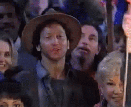 Man in Hat Sitting in Crowd