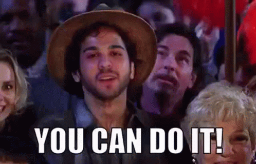 Man in Hat Sitting in Crowd Saying You Can Do It