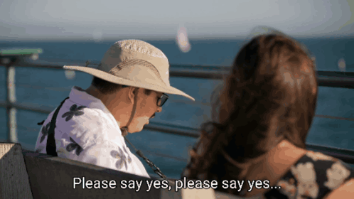 Man In Hat Sitting Next To Woman Saying Please Say Yes GIF