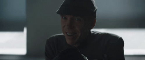 Man in Hat Smiling in Dark Room