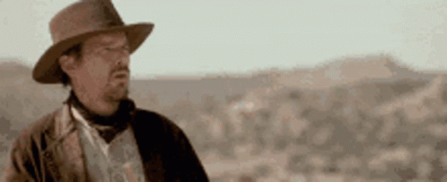 Man in Hat Standing in Desert