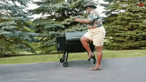 Man in Hat Standing on Grill