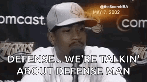 Man in Hat Talking Into Microphone About Defense Man
