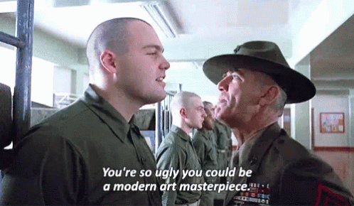 Man in Hat Talking to Man in Military Uniform With Another Man Looking On