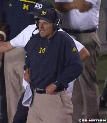 Man in Hat With Letter M Standing on Field