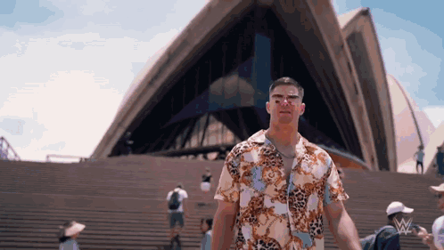Man In Hawaiian Shirt On Stairs In Front Of Building GIF