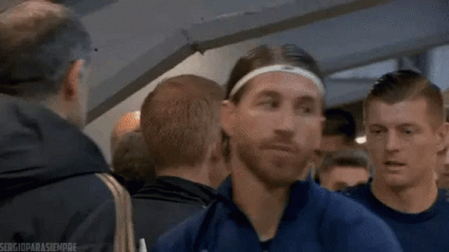 Man in Headband and Blue Jacket Standing in Crowd