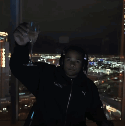 Man in Headphones and Black Puma Jacket Holding Wine Glass