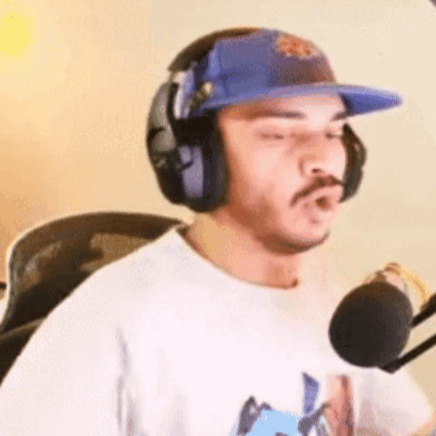Man in Headphones and Hat at Microphone