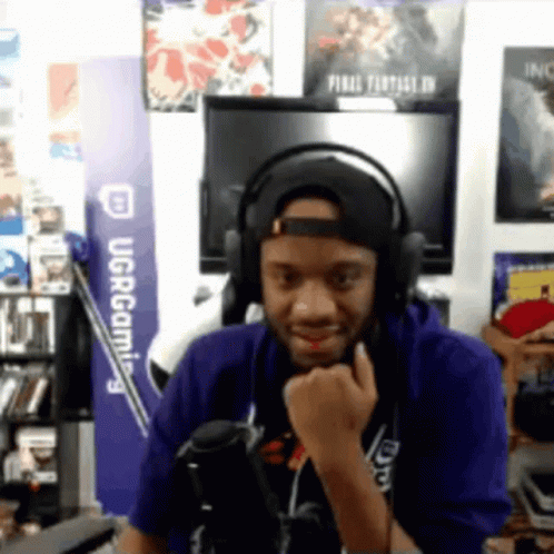 Man in Headphones and Hat at UCR Gaming Sign