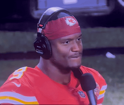 Man in Headphones and K Headband Talking Into Mic