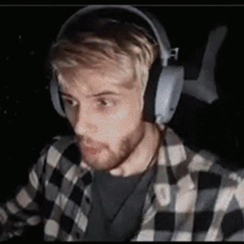 Man in Headphones and Plaid Shirt Sitting