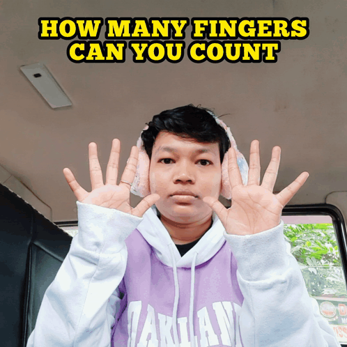 Man in Headphones and Purple Takuan Sweatshirt Holding Up Fingers
