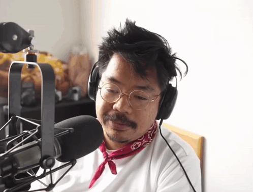 Man in Headphones and Red Bandana Talking Into Microphone