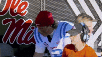 Man in Headphones and Red Beanie at Ole Miss Sign