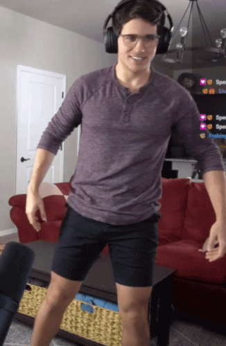 Man in Headphones and Shorts by Couch