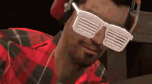 Man in Headphones and Sunglasses Looks at Camera