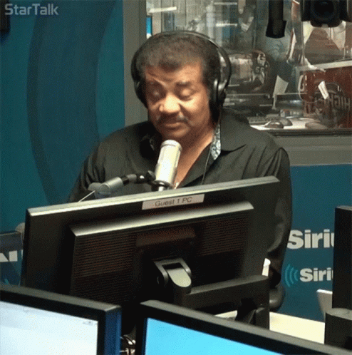 Man in Headphones at Microphone Labeled Guest 1 PC