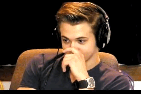 Man In Headphones Covering Nose With Hand GIF