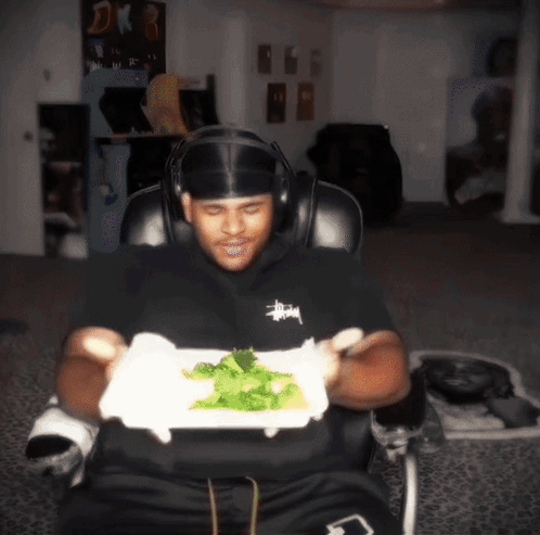 Man in Headphones Holding Plate of Food