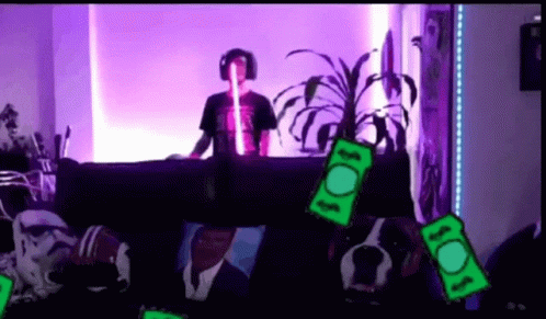 Man In Headphones Sits On Couch Surrounded By Money GIF